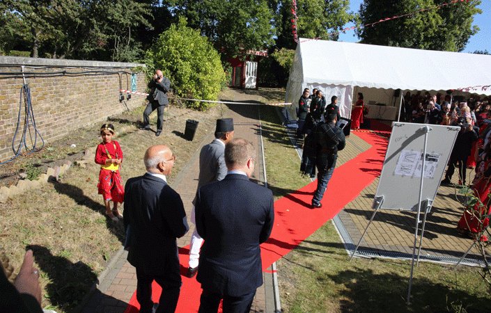 A bagpipe player leads the guests of honour along the red carpet